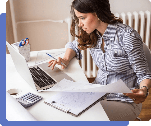 A woman sitting at her desk looking at papers.